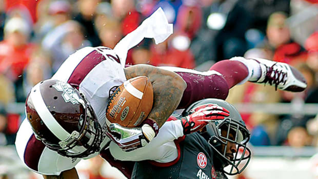 Mississippi State Bulldogs running back LaDarius Perkins (27) dives into the end zone against Arkansas Razorbacks safety Eric Bennett (14) during the second quarter at War Memorial Stadium.